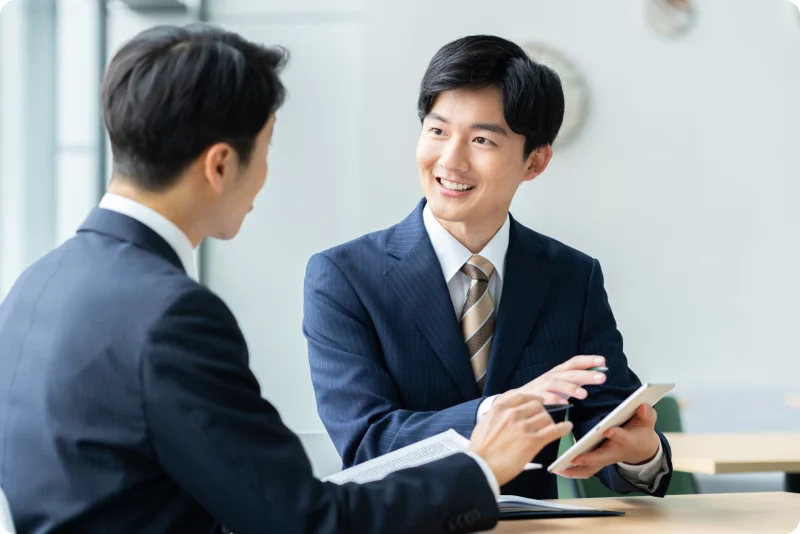 タブレットを使って説明するスーツ姿の男性